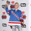 Justin Bieber apostou no street style para ir ao iHeartRadio Music Awards. O cantor usou calça jeans destroyed, blusa do time de futebol americano Rangers e tênis de cano alto