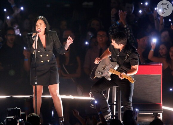 Já no palco do iHeartRadio Music Awards, Demi Lovato usou um vestido-terninho preto Balmain, deixando as pernas à mostra