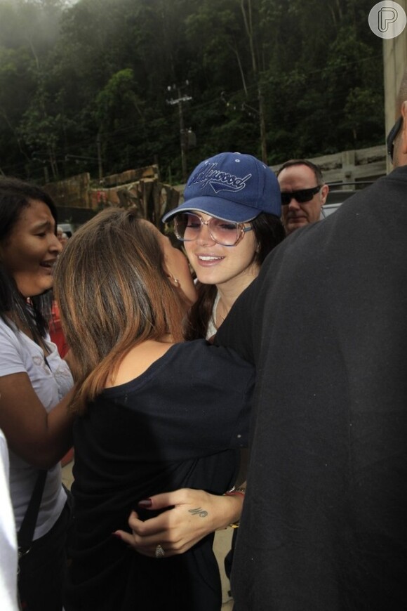 De óculos escuros e boné, Lana dá abraço em fã