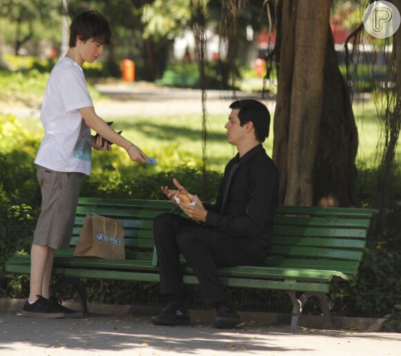 Sem dinheiro e sem ter para onde ir, Félix (Mateus Solano) é obrigado a comer um pão com mortadela que ganha de Jonathan (Thalles Cabral), mesmo achando que o lache é coisa de pobre, em 'Amor à Vida'