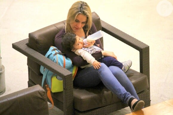 Fernanda Gentil foi fotografada em um shopping da Barra da Tijuca, Rio de Janeiro, dando mamadeira para o filho, Gabriel, que completou 1 ano neste domingo, 28 de agosto de 2016