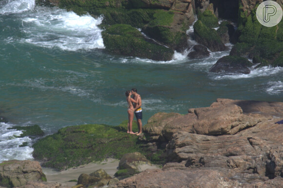 Cauã Reymond troca carinhos com a namorada, Mariana Goldfarb, na praia da Joatinga