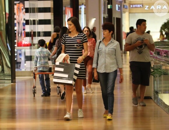 Camila Queiroz usou vestido de mangas preto com listras brancas e tênis para passeio no shopping com a mãe
