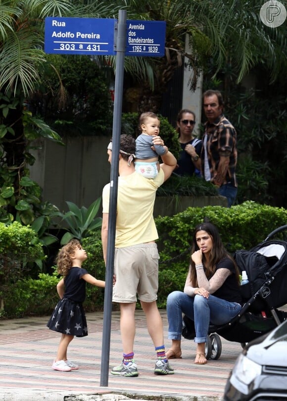 Camila Alves senta no carrinho de bebê enquanto Matthew McConaughey carrega Livingston, de apenas 11 meses, no colo