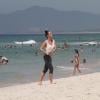 Juliana Didone vai à praia da Barra da Tijuca, no Rio, de roupa e cai no mar