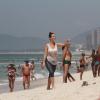 Simpática, Juliana Didone aparece na praia da Barra para correr e tomar banho de mar e acena para fã