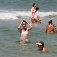 Juliana Didone mergulha de roupa no mar da praia da Barra da Tijuca, no RJ