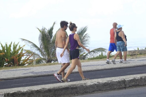 Juliana Didone e o namorado Flávio Rossi caminham na orla da Barra da Tijuca, no Rio; o namoro dos dois já ultrapassa três meses