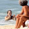 Cláudia Abreu chama o filho para mergulhar junto com ela na praia do Leblon