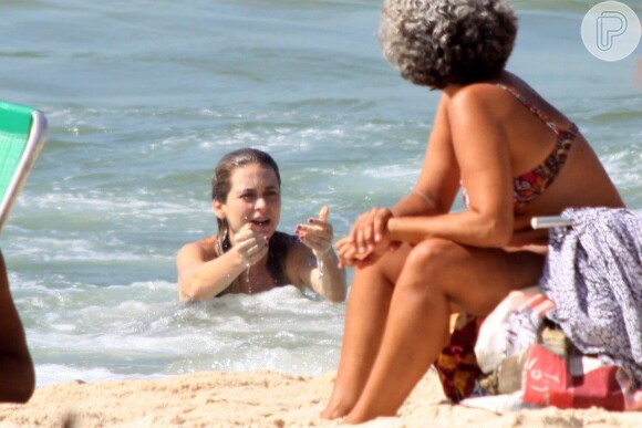 Cláudia Abreu chama o filho para mergulhar junto com ela na praia do Leblon