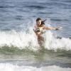 Grazi sai do mar e corre na areia para se vestir. Antes de deixar a praia a atriz atendeu ao pedido de fotos com fãs