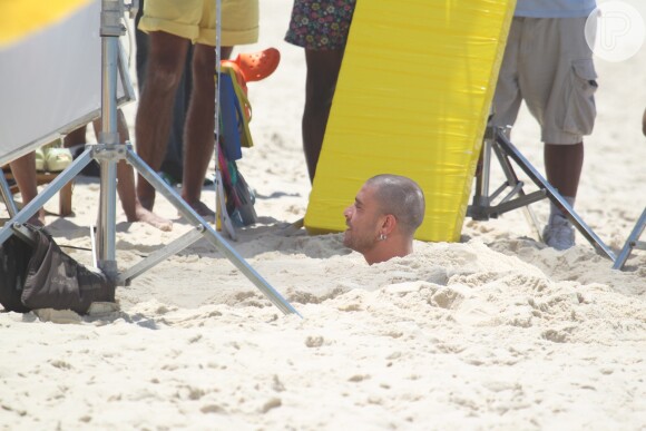 Diogo Nogueira aparece enterrado na areia durante as gravaçõesa na praia da Reserva, na Zona Oeste do Rio de Janeiro