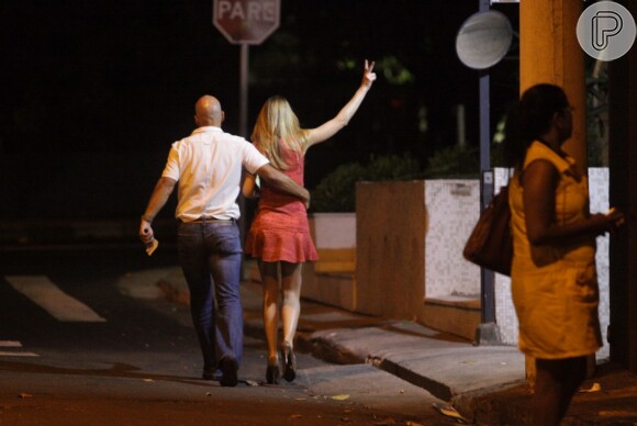 Ticiane Pinheiro sai de boate abraçada com um homem e acena para as pessoas na rua