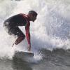 Caio surfou usando uma roupa de neoprene, própria para praticar o esporte e proteger o corpo da água fria do mar