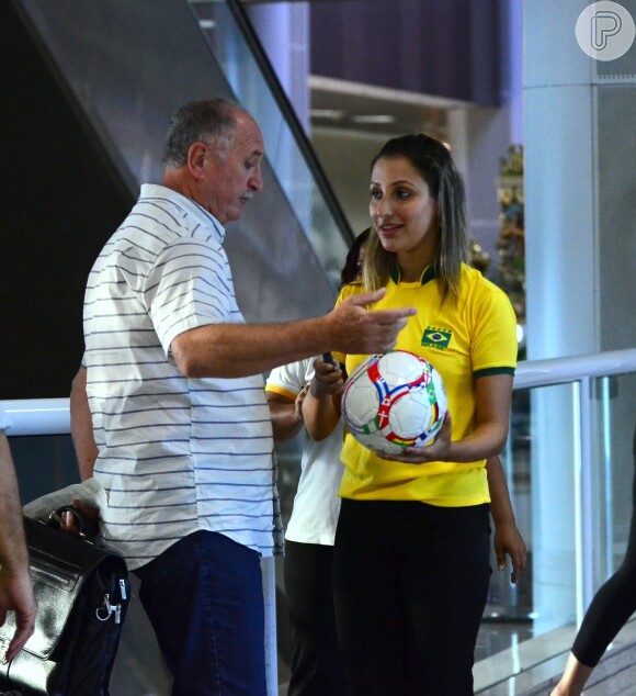 Felipão conversou rapidamente com a fã, que usava uma camisa do Brasil, enquanto ela exibia a bola para ele e pedia foto
