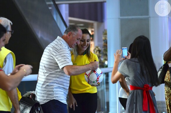 Enquanto o técnico da Seleção Brasileira autografa a bola, outros fãs registram o momento no aeroporto Santos Dumont, no Rio de Janeiro, na tarde desta quarta-feira, 12 de março de 2014