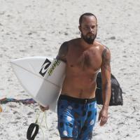 Paulinho Vilhena, no ar em 'A Teia', exibe tatuagens e cai de prancha ao surfar