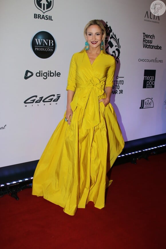 Para o leilão promovido pelo Instituto Neymar Jr., Claudia Leitte usou um vestido amarelo Carolina Herrera no valor de R$ 6.980 