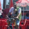Thiago Lacerda chegou pedalando acompanhado pela filha na praia da Barra da Tijuca, no Rio