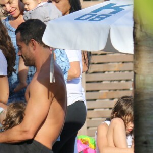 Malvino Salvador segura a filha Ayra no colo enquanto a menina toma mamadeira