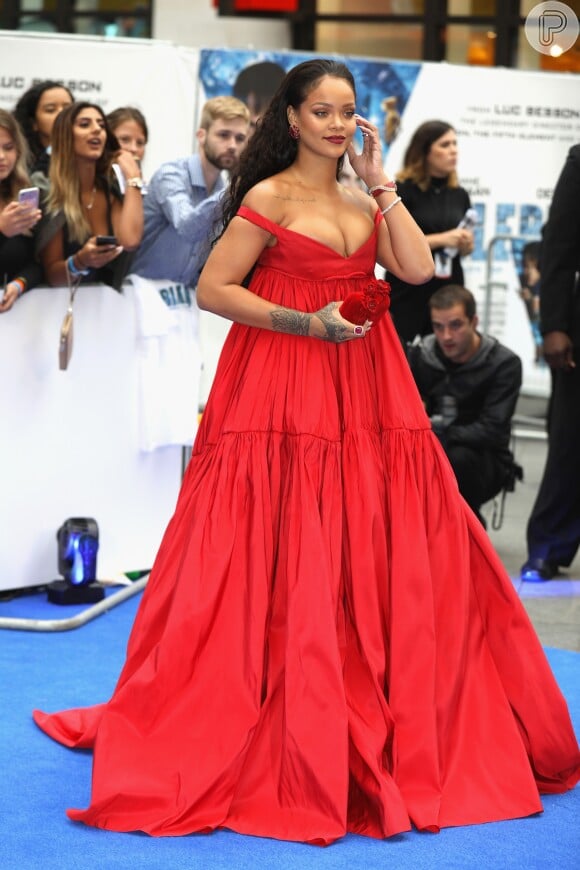 Rihanna roubou a cena ao surgir com um look vermelho Giambattista Valli extremamente decotado, joias Chopard, bolsa Jimmy Choo e batom combinando com o vestido na première do filme 'Valerian e a Cidade dos Mil Planetas'