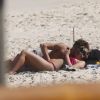 Isabella Santoni, de topless, e João Vithor Oliveira trocaram carinhos na praia