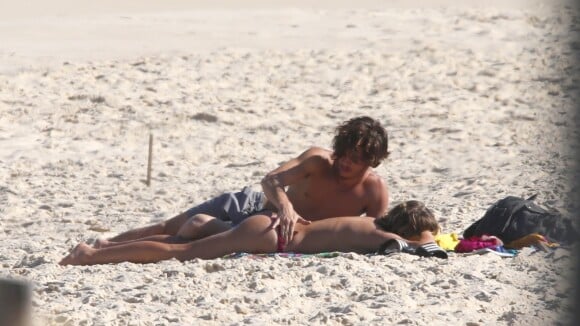 Isabella Santoni, de topless, ganha carinho de João Vithor Oliveira na praia
