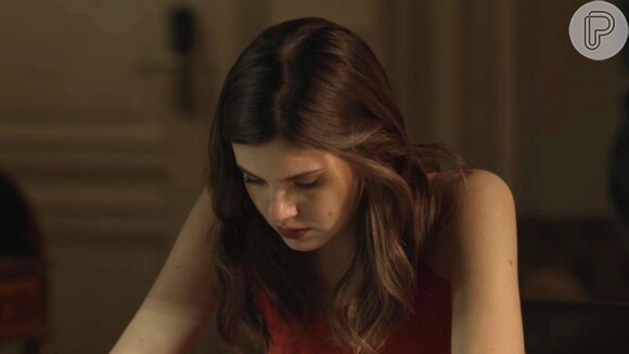 Luiza (Camila Queiroz) estuda o inquérito do acidente que matou Mirella (Marina Rigueira), na novela 'Pega Pega '