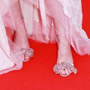 Detalhe das sandálias de Elle Fanning, composta por laços com aplicações de pedras