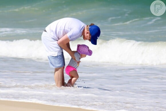 Michel Teló se diverte com a filha, Melinda, nas ondas da praia da Barra da Tijuca