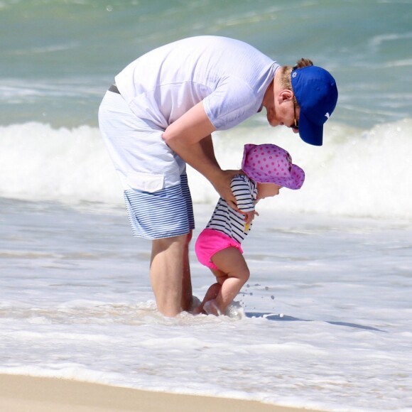 Michel Teló se diverte com a filha, Melinda, nas ondas da praia da Barra da Tijuca