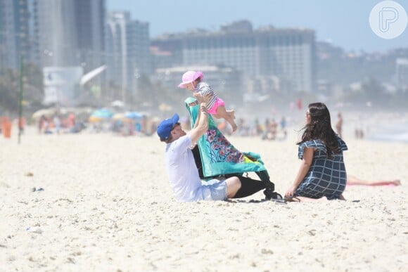 Michel Teló levanta a filha, Melinda, em brincadeira na praia
