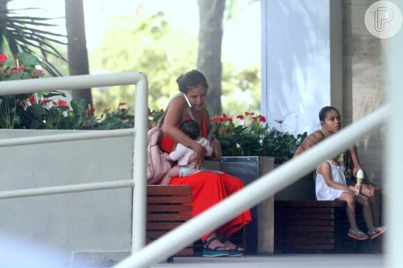Yanna Lavigne amamenta a filha, Madalena, do lado de fora de shopping