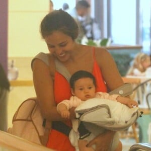 Yanna Lavigne, com Madalena em um canguru na frente de seu corpo, passeia no Fashion Mall