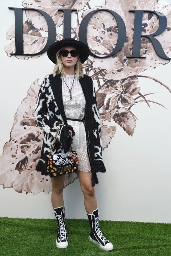 Com um estilo descolado, Jennifer Lawrance combinou as botas com o casaco para prestigiar o desfile de alta-costura que celebrou os 70 anos da Dior, em Paris, na França, em 3 de julho de 2017