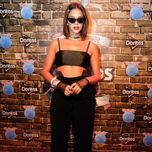 Bruna Marquezine atraiu olhares no Rock in Rio com uma produção fashionista com óculos pontudos, top, luvas, calça de cintura alte e tênis branco