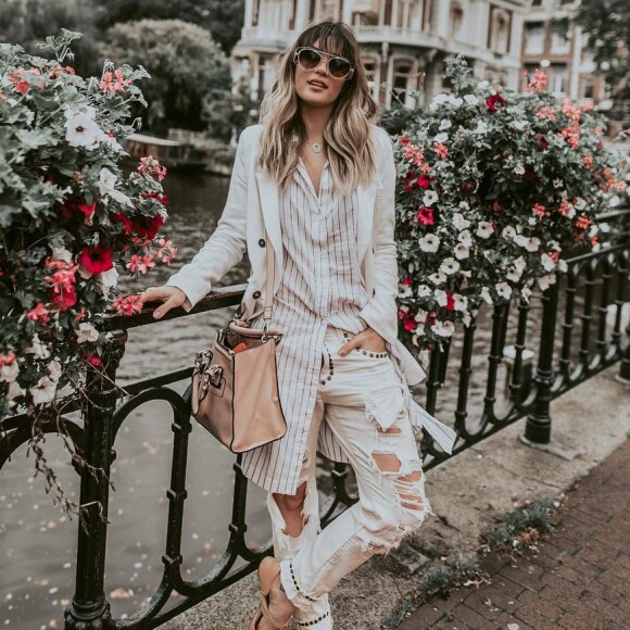 Durante conexão em Amsterdã, na Holanda, Aline Gotschalg exibiu um look despojado e arrumadinho com calça destroyed e flats