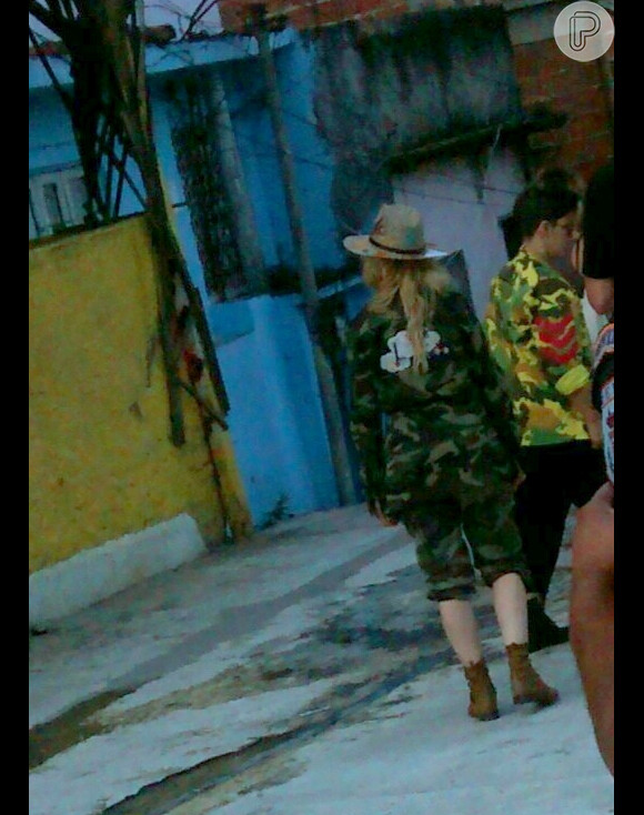 Madonna escolheu um look listrado para visitar a comunidade carioca