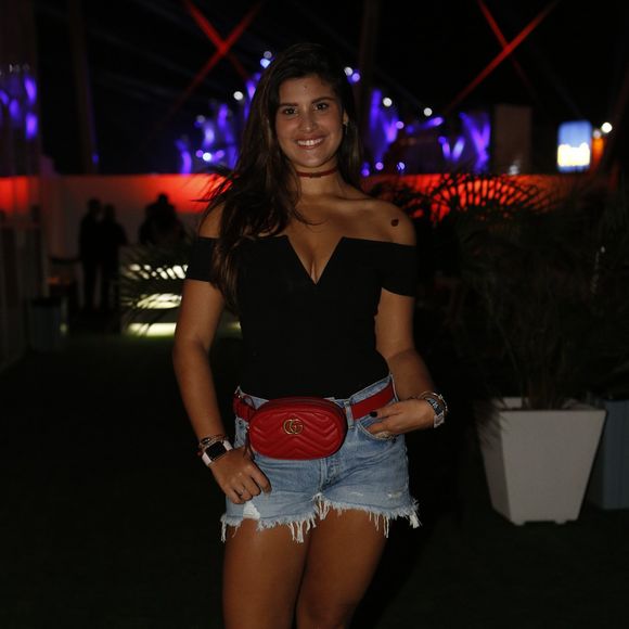 Giulia Costa optou pelo mesma pochete grifada, em vermelho, para complementar seu look básico no Rock in Rio 2017