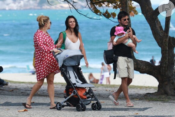 Yanna Lavigne e Bruno Gissoni caminharam com a filha, Madalena, na orla da praia da Barra da Tijuca