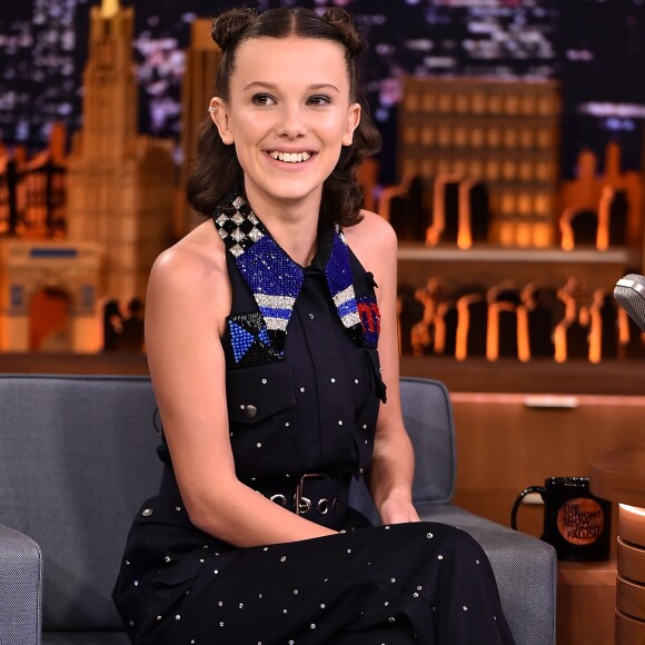 Com pequenos coques no cabelo e um macacão com aplicações, Millie Bobby Brown foi entrevistada por Jimmy Fallon no programa 'The Tonight Show', em Nova York, em 31 de outubro de 2017