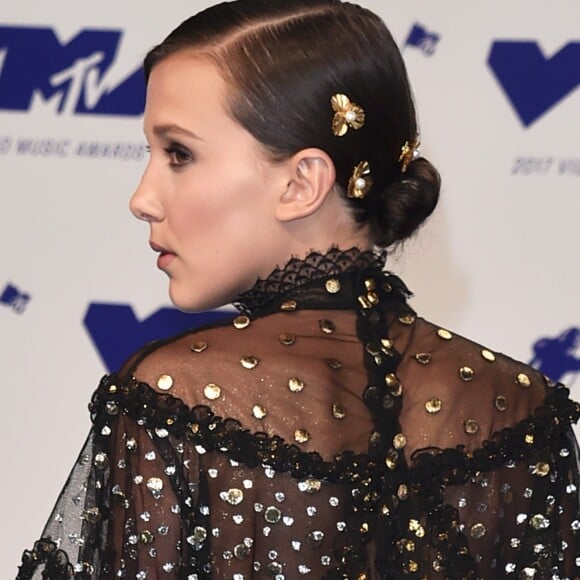 Millie Bobby Brown usou pequenos ornamentos dourados presos ao penteado com coque