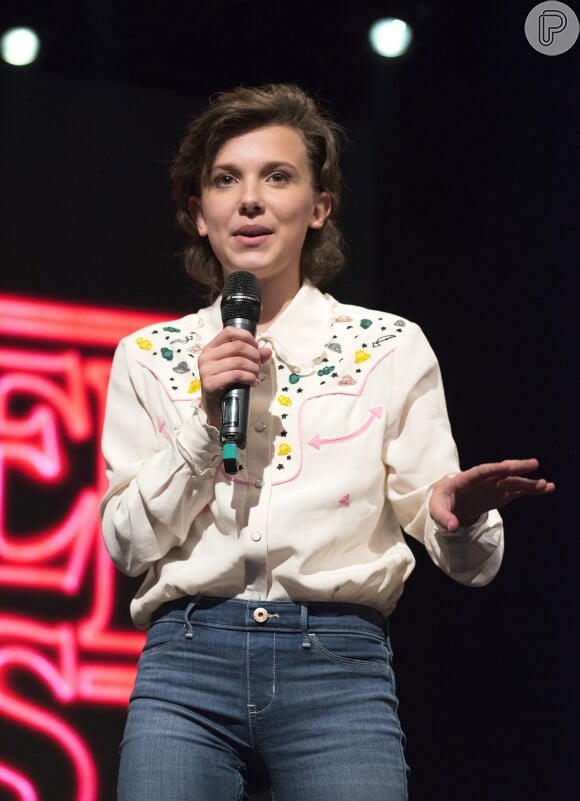 Com o cabelo solto, Millie Bobby Brown investiu em um visual mais country ao combinar jeans e camisa com bordados na 'Argentina Comic Con', em Buenos Aires, na Argentina, em 26 de maio de 2017