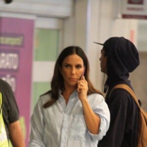 Grávida de 6 meses, Ivete Sangalo chegou falando ao telefone no aeroporto