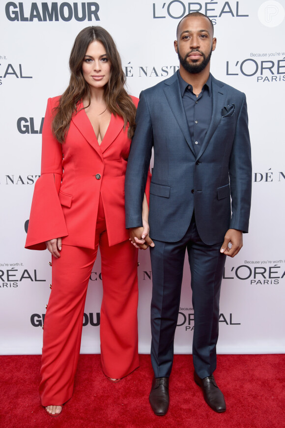 Ao lado do marido, Justin Ervin, a modelo Ashley Graham exibiu um conjunto de alfaiataria com calça de botões laterais e acabamento boca de sino no prêmio Glamour's 2017 Women of The Year, realizado no Brooklyn, em Nova York, em 13 de novembro de 2017