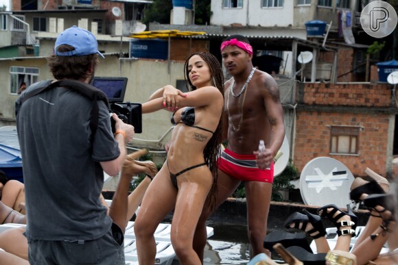 Anitta toma banho de sol na laje com biquíni de fita isolante no clipe 'Vai Malandra'