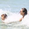 Em Florianópolis, Alessandra Ambrósio ajuda o filho a surfar em dia de praia, nesta quinta-feira, 4 de janeiro de 2018