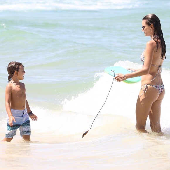 Em Florianópolis, Alessandra Ambrósio ajuda o filho a surfar em dia de praia, nesta quinta-feira, 4 de janeiro de 2018
