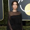 Angelina Jolie surgiu deslumbrante ao desfilar sobre o tapete vermelho com vestido preto Atelier Versace 