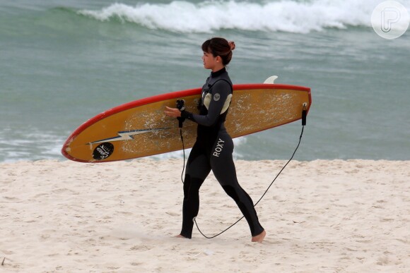 Pérola Faria encarou o tempo nublado em dia de aula de surfe, em praia do Rio de Janeiro
